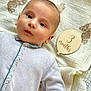 baby, infant, 3_months, blanket, teddy_bear_pattern, wooden_sign, face, eyes, clothing, onesie, hand, floor, carpet, portrait, cute, child, laying_down, soft_texture, newborn, indoors