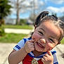 baby, bodypart, clothing, face, finger, grass, hand, happy, head, laughing, mouth, outdoors, person, photography, plant, portrait, smile, t_shirt, teeth, tree