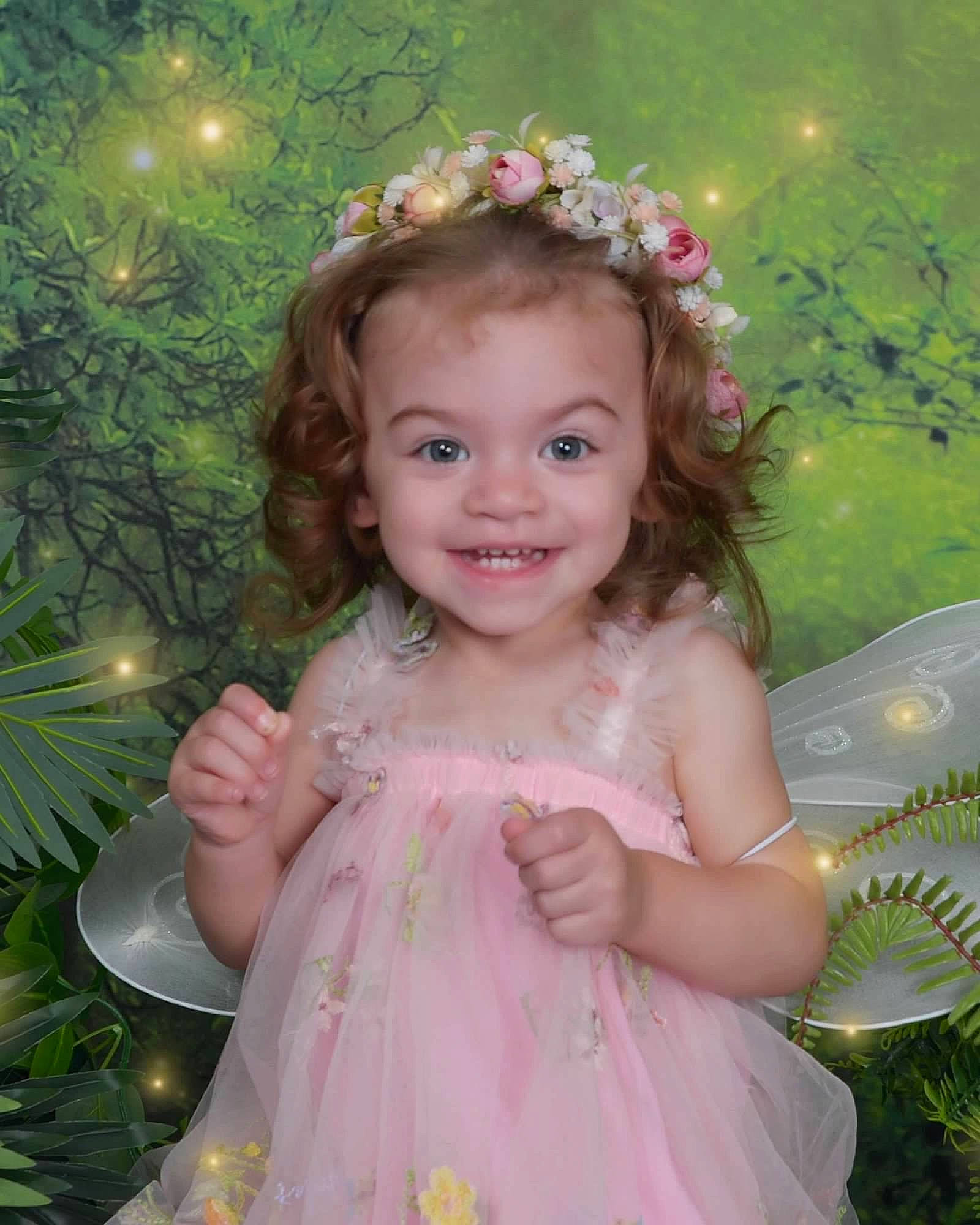 Amelia is registered to the contest to win money with this photo: baby_toddler_clothing, beauty, clothing, dress, eye, grass, hairstyle, happy, head, headpiece, iris, joy, leaf, people_in_nature, person, petal, pink, plant, skin, smile