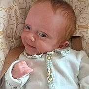 Mary participe au concours pour gagner de l'argent avec cette photo : baby, infant, smile, face, clothing, seat, cushion, pattern, animal_print, button, hand, skin, head, eyes, cute, portrait, child, baby_clothes, relaxing, indoors