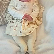 Mary participe au concours pour gagner de l'argent avec cette photo : baby, blanket, bow, child, cozy, cute, face, headband, indoors, infant, lying_down, person, pillow, portrait, smile, soft_texture, teddy_bear_print, warm, white_clothing, young_child