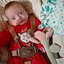 Mary participe au concours pour gagner de l'argent avec cette photo : baby, infant, red_clothing, onesie, baby_seat, safety_harness, soft_toy, plush_toy, cute, indoors, child, face, expression, holiday_theme, reindeer, patterned_fabric, comfort, seat, person, newborn