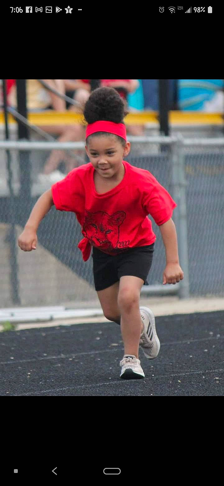 Lilliana is registered to the contest to win money with this photo: asphalt, athlete, athletics, baseball_cap, cap, competition_event, exercise, footwear, happy, headwear, human_leg, person, recreation, road, running, shorts, smile, sneakers, sports, sportswear