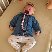 Alba participe au concours pour gagner de l'argent avec cette photo : baby, sleeping, crib, pacifier, headband, denim_jacket, pants, heart_pattern, socks, toy, bed, infant, child, peaceful, indoors, clothing, cute, resting, soft_toys, nursery