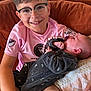 Menzo participe au concours pour gagner de l'argent avec cette photo : child, baby, boy, infant, glasses, smiling, sitting, holding, couch, clothing, onesie, pacifier, beads, happy, portrait, indoors, face, pattern, furniture, home