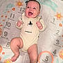 Alina is registered to the contest to win money with this photo: baby, infant, smiling, onesie, headband, milestone_blanket, months, happy, lying_down, flower_pattern, cute, child, playful, pink_ring, celebration, joyful, face, skin, hand, foot
