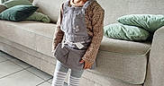 Linaya a rejoint le concours — aidez-le/la à gagner de superbes lots ! child, cozy, curtains, furniture, girl, green_pillows, happy, indoors, living_room, overalls, painting, portrait, smiling, sneakers, sofa, standing, striped_tights, tiled_floor, wall_lamp, wood_paneling