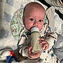Michal is registered to the contest to win money with this photo: baby, bottle, milk, blanket, onesie, toy, plush, infant, cute, sleeping_area, child, blue_eyes, hand, face, comfort, soft_toy, bedtime, clothing, lying_down, feeding