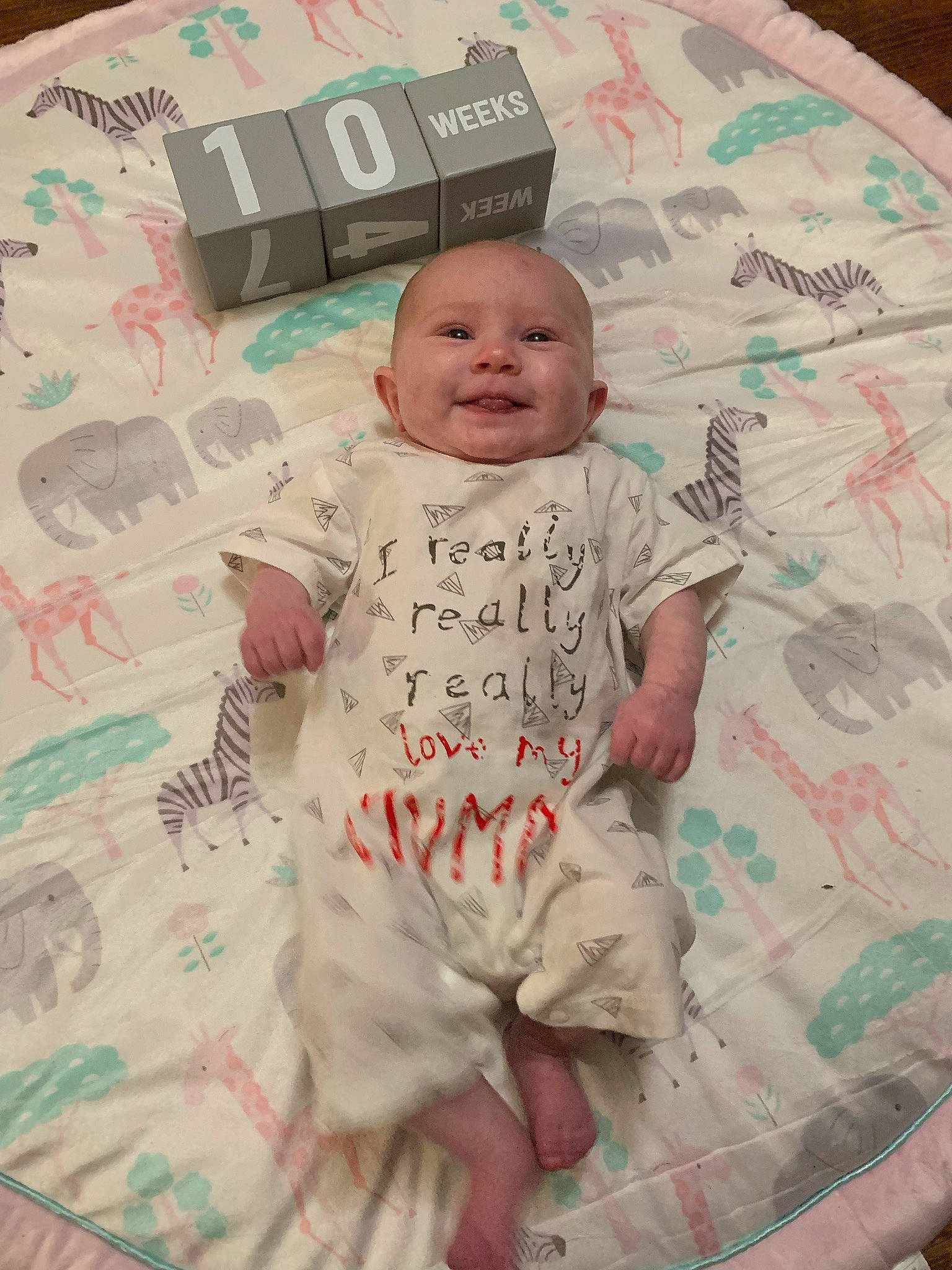 Averi is registered to the contest to win money with this photo: baby, baby_products, baby_safety, baby_toddler_clothing, bedding, cheek, child, comfort, face, happy, head, linens, pattern, person, pink, skin, sleeve, smile, t_shirt, textile