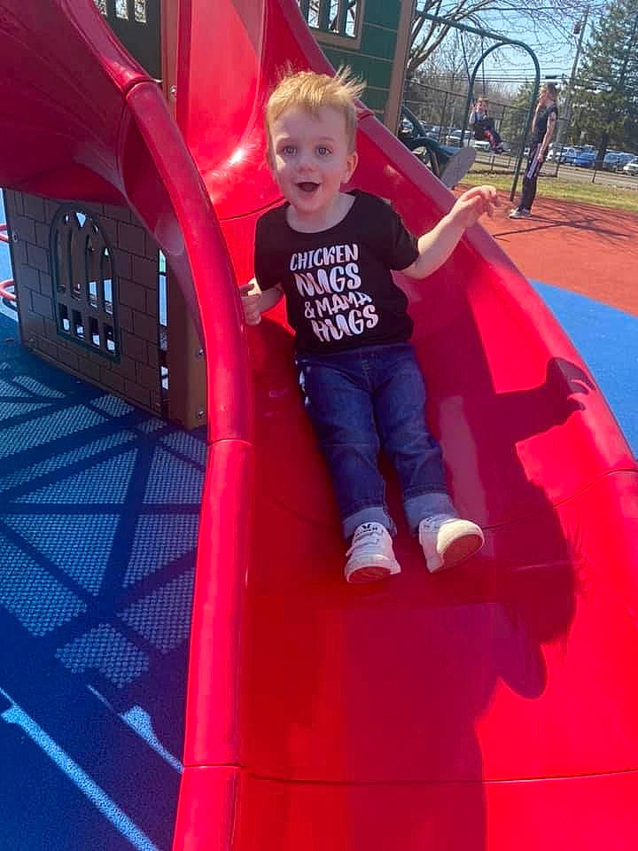Benjimin is registered to the contest to win money with this photo: child, chute, city, electric_blue, fun, grass, human_settlement, leisure, magenta, outdoor_play_equipment, person, photograph, pink, playground, playground_slide, public_space, recreation, red, t_shirt, toddler