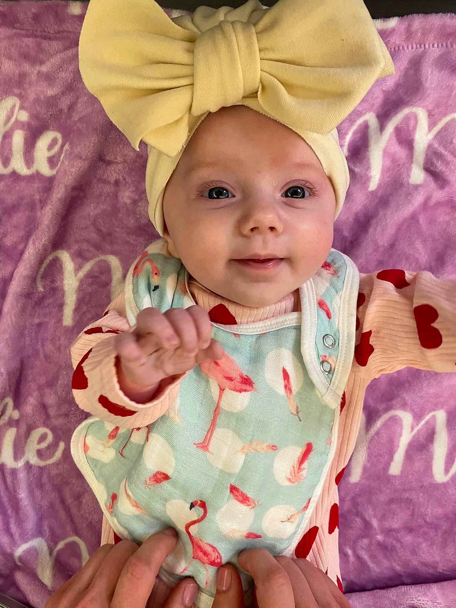 Melodie is registered to the contest to win money with this photo: baby, baby_toddler_clothing, cheek, chin, collar, dress, eye, face, gesture, hand, happy, head, headwear, linens, person, pink, product, skin, sleeve, smile