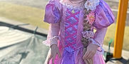 Aurore participe au concours pour gagner de l'argent avec cette photo : child, girl, princess, costume, pink_dress, purple_dress, braid, flowers, smile, playground, outdoors, sunlight, portrait, happy, candid, young_child, hair_accessory, fairy_tale, shallow_depth_of_field, daylight