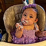 Aubriella joined the competition — help win amazing prizes! baby, child, high_chair, birthday_cake, crown, purple_dress, frosting, face_paint, smiling, celebration, first_birthday, messy, happy, indoor, person, toddler, hand, seat, cute, party