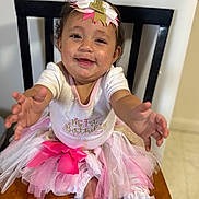 Aubriella is registered to the contest to win money with this photo: baby, child, smiling, birthday, tutu, headband, pink, white, table, chair, happy, celebration, cute, person, indoor, clothing, foot, reaching, portrait, first_birthday