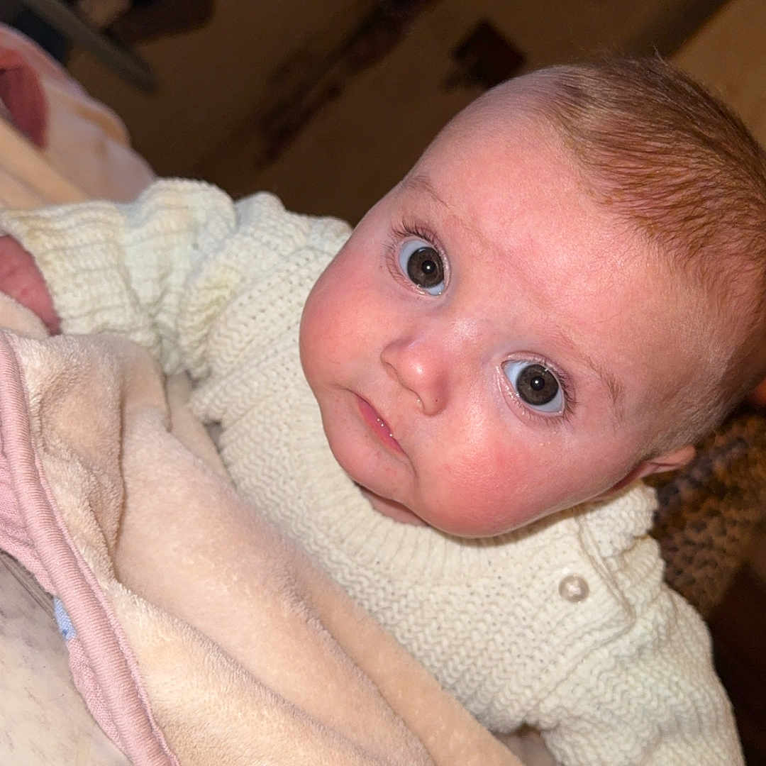 Maria a rejoint le concours — aidez-le/la à gagner de superbes lots ! baby, bed, blanket, blanket_fold, cheeks, child, closeup, cozy, eyes, face, gaze, hair, indoor, infant, knit_sweater, newborn, portrait, skin, sweater, wide_eyes