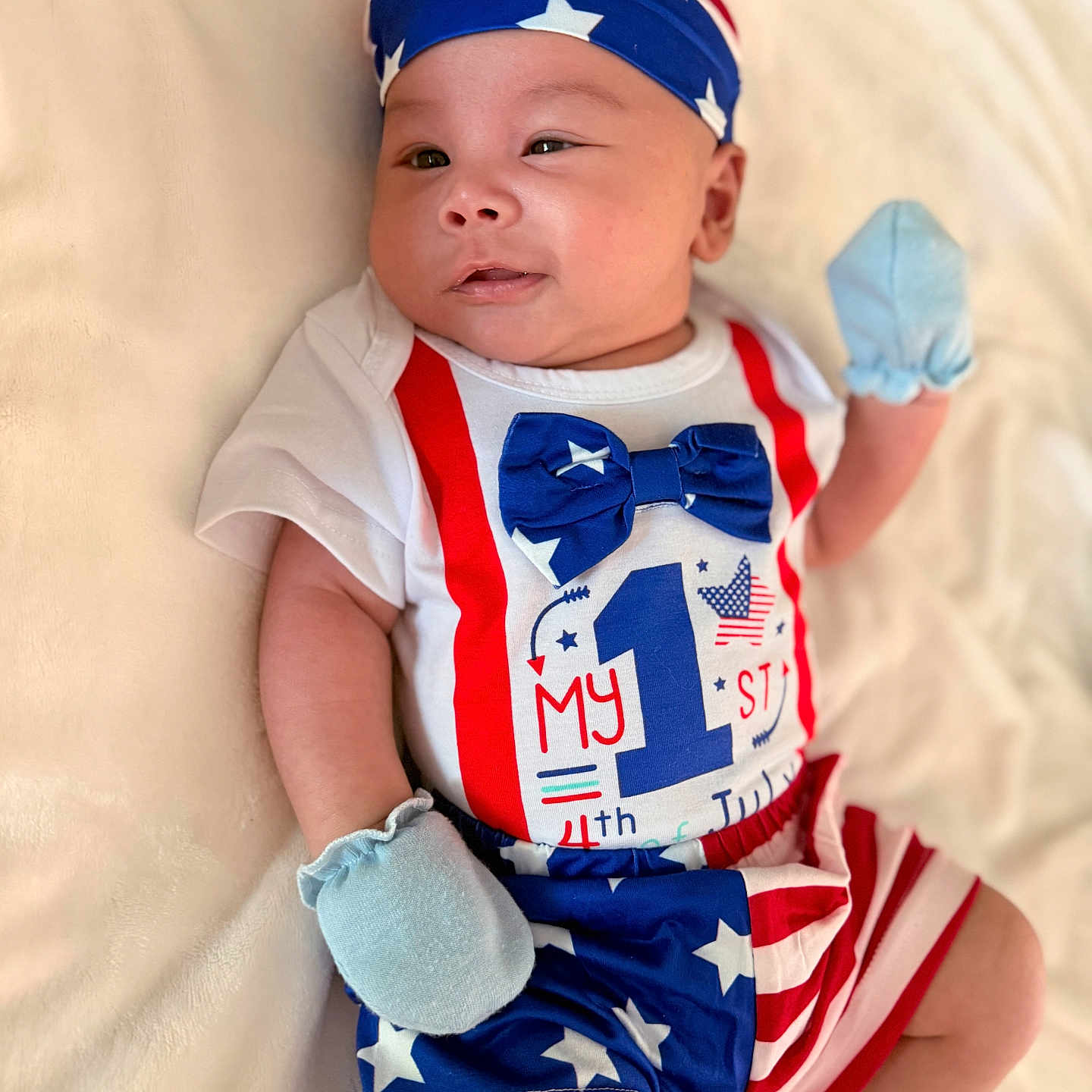 Quincy is registered to the contest to win money with this photo: 4th_of_july, baby, blanket, blue, celebration, clothing, comfortable, cute, first_birthday, headband, holiday, infant, lying_down, mittens, portrait, red, soft_texture, stars, stripes, white