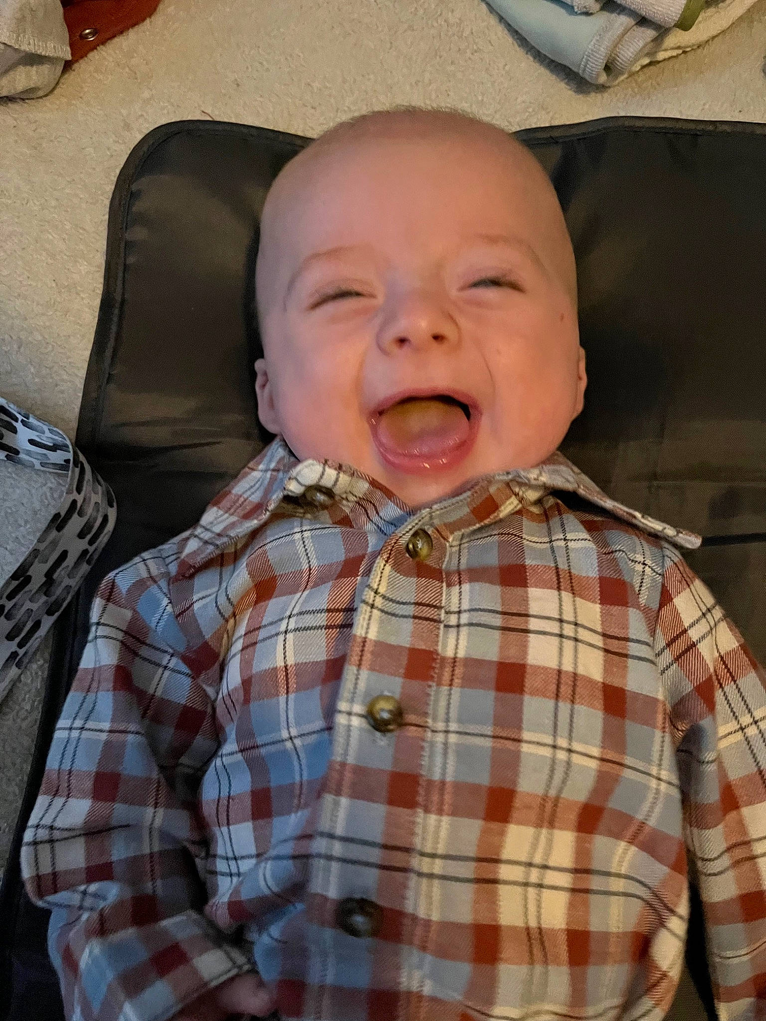 Sebastian is registered to the contest to win money with this photo: baby, baby_laughing, baby_toddler_clothing, cheek, child, chin, collar, comfort, dress_shirt, fun, happy, nose, pattern, person, plaid, sitting, sleeve, smile, tartan, textile