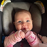 Adalee is registered to the contest to win money with this photo: baby, child, car_seat, pink_clothing, hands, fingers, blue_eyes, face, infant, cute, rosy_cheeks, sitting, seatbelt, soft_lighting, indoor, closeup, portrait, playful, cozy, smiling