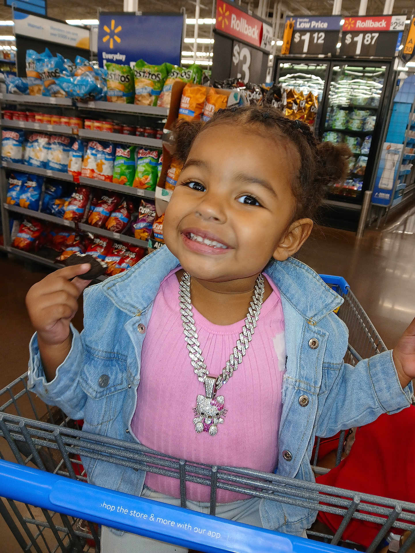 Naomi joined the competition — help win amazing prizes! toddler, child, shopping_cart, grocery_store, smiling, cookie, denim_jacket, pink_shirt, necklace, hello_kitty, braided_hair, snacks, chips, aisle, price_sign, retail, shopping, happy, face, person