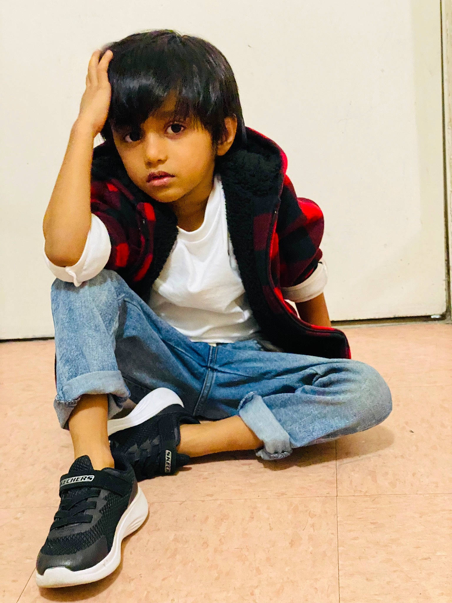 Avin is registered to the contest to win money with this photo: black_hair, cheek, cool, denim, elbow, face, flooring, happy, jeans, joint, knee, leg, person, shoe, sitting, sleeve, sneakers, standing, thigh, toddler