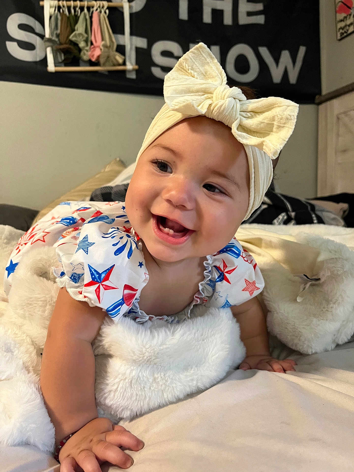 Iliana joined the competition — help win amazing prizes! baby, smiling, headband, bow, infant, blanket, bed, clothing, star_pattern, happy, face, child, indoors, cute, person, portrait, skin, hand, fabric, room