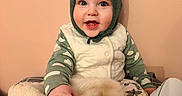 Adan a rejoint le concours — aidez-le/la à gagner de superbes lots ! baby, blanket, child, clothing, cozy, cute, face, happy, hat, home, indoor, infant, knit_hat, person, portrait, sitting, smiling, stuffed_animal, toy, warm_colors