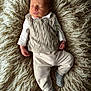 Gabriel participe au concours pour gagner de l'argent avec cette photo : newborn, baby, sleeping, knitwear, socks, white_shirt, beige_pants, beige_vest, fluffy_rug, soft_texture, cozy, infant, portrait, indoors, peaceful, resting, cute, small_hands, small_feet, warm_lighting