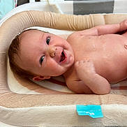 Maddie joined the competition — help win amazing prizes! baby, infant, smile, face, skin, hand, bath, bathroom, cushion, soft, cute, happy, lying_down, child, newborn, water, expression, indoors, closeup, person