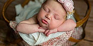 Maddie joined the competition — help win amazing prizes! baby, newborn, sleeping, headband, flower, basket, blanket, wooden_floor, infant, peaceful, soft_focus, portrait, cute, resting, cozy, pink, delicate, closeup, child, adorable