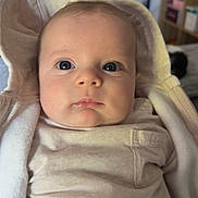 Ayden participe au concours pour gagner de l'argent avec cette photo : baby, infant, face, blue_eyes, clothing, hood, indoor, portrait, child, cute, young, person, skin, sitting, expression, newborn, soft_lighting, warm, cozy, home