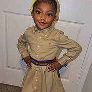 Kiyanna joined the competition — help win amazing prizes! child, girl, portrait, smiling, standing, indoors, door, bow, hair_bow, ponytail, dress, shirt, belt, fashion, outfit, hands_on_hips, brown_hair, earrings, carpet, photography