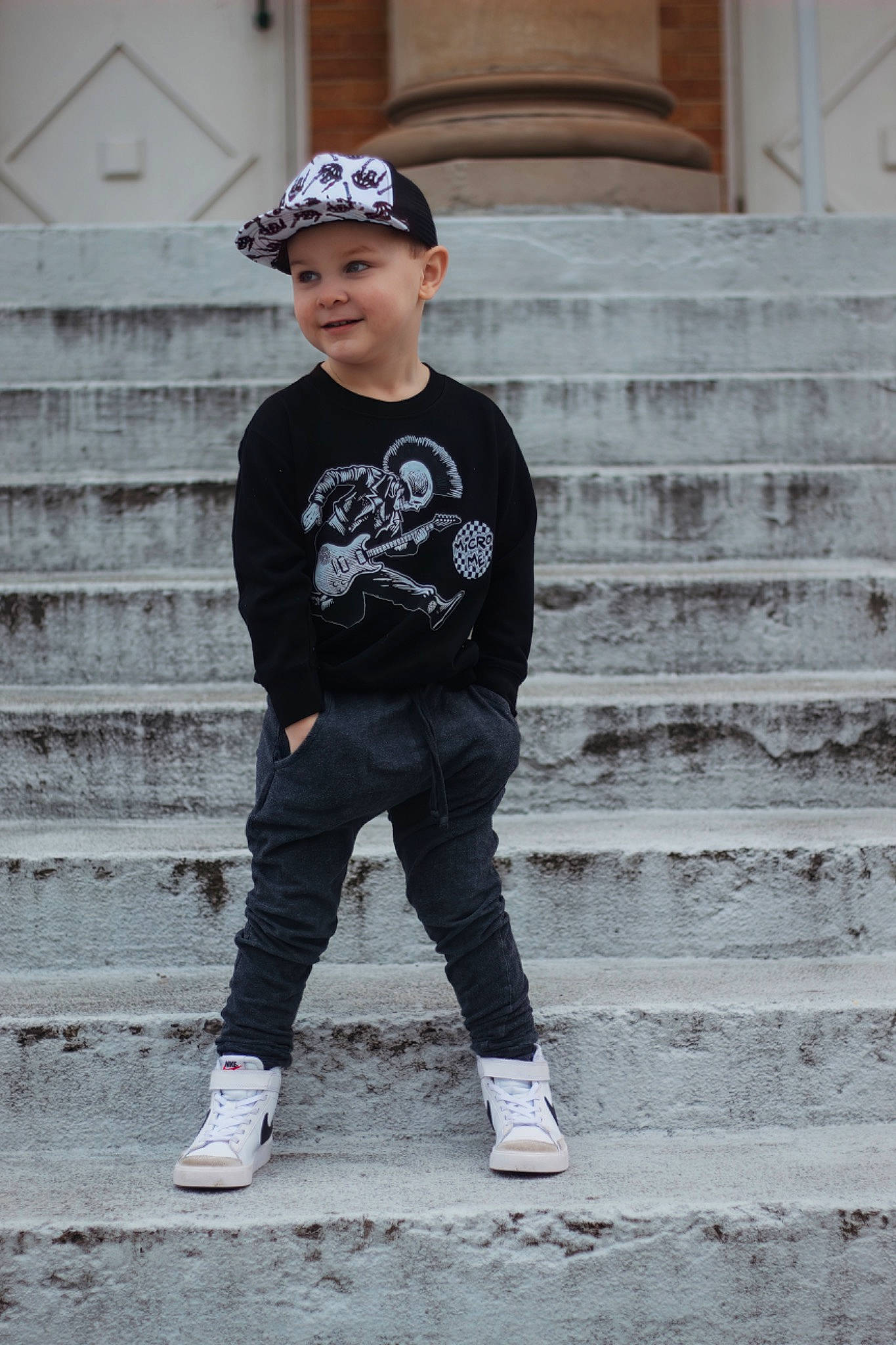 Maverick is registered to the contest to win money with this photo: baseball_cap, cap, child, electric_blue, fashion_design, flash_photography, grey, hat, headgear, headwear, joy, monochrome, monochrome_photography, pattern, person, sitting, sleeve, smile, stairs, street