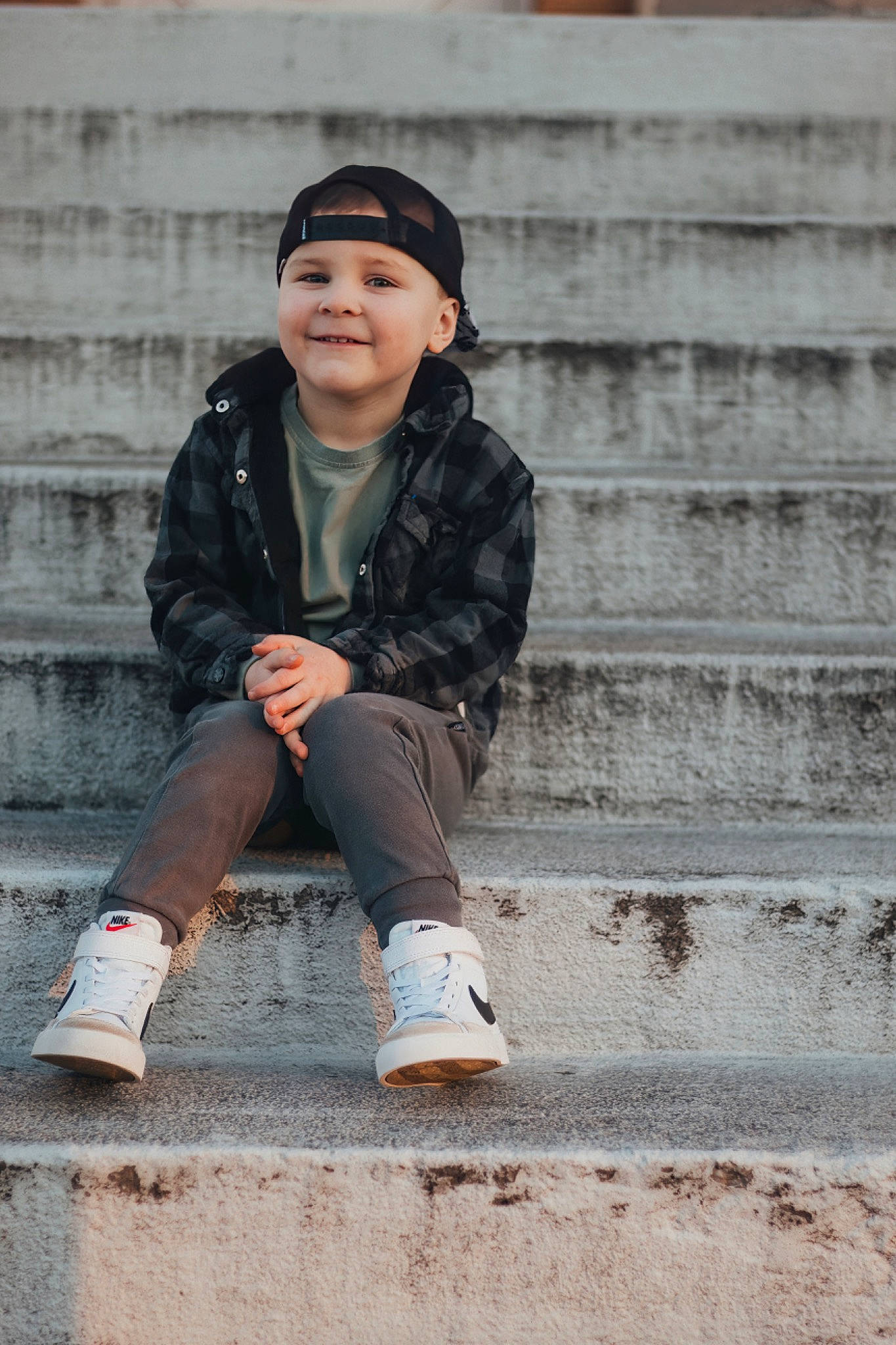 Maverick is registered to the contest to win money with this photo: brick, cap, child, cool, denim, flash_photography, happy, headwear, human_leg, joy, knee, outerwear, pattern, person, photo_shoot, portrait_photography, sitting, sleeve, smile, standing