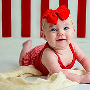 Isabella joined the competition — help win amazing prizes! baby, child, red_bow, smile, blue_eyes, blanket, tummy, red_outfit, striped_background, indoor, cute, infant, portrait, happy, face, headband, soft_texture, person, crawling, bright