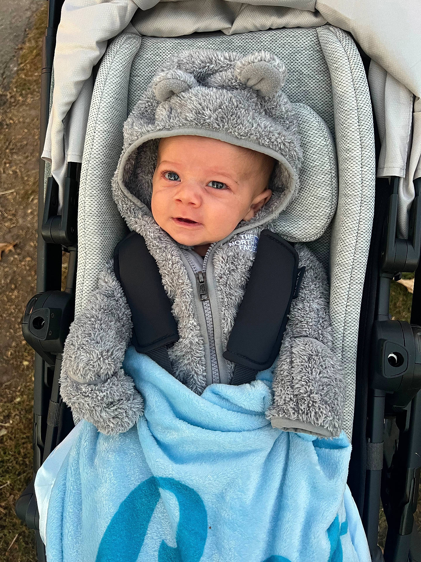 Leo is registered to the contest to win money with this photo: baby, blanket, bonnet, cap, clothing, coat, face, happy, hat, head, hood, hoodie, jacket, knitwear, person, photography, portrait, stroller, sweater, sweatshirt