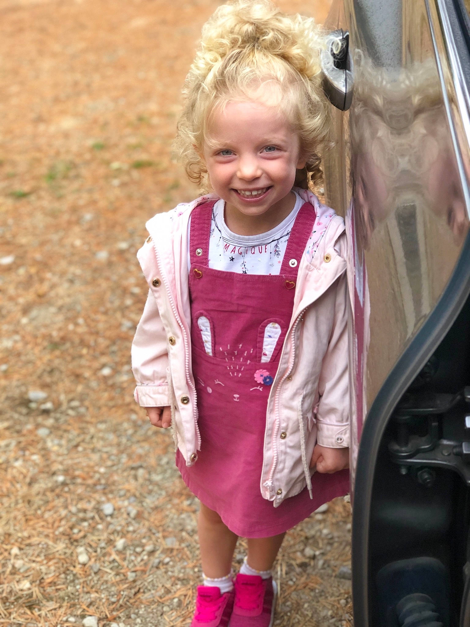 Victoire participe au concours pour gagner de l'argent avec cette photo : automotive_exterior, blond, clothing, face, family_car, fun, grass, happy, joy, leisure, magenta, motor_vehicle, people_in_nature, person, pink, public_space, recreation, skin, smile, toddler