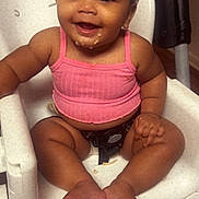 Amari is registered to the contest to win money with this photo: baby, child, high_chair, pink_top, smiling, food_crumbs, messy, cute, happy, indoor, skin, face, feet, hands, curly_hair, seatbelt, infant, person, sitting, meal_time
