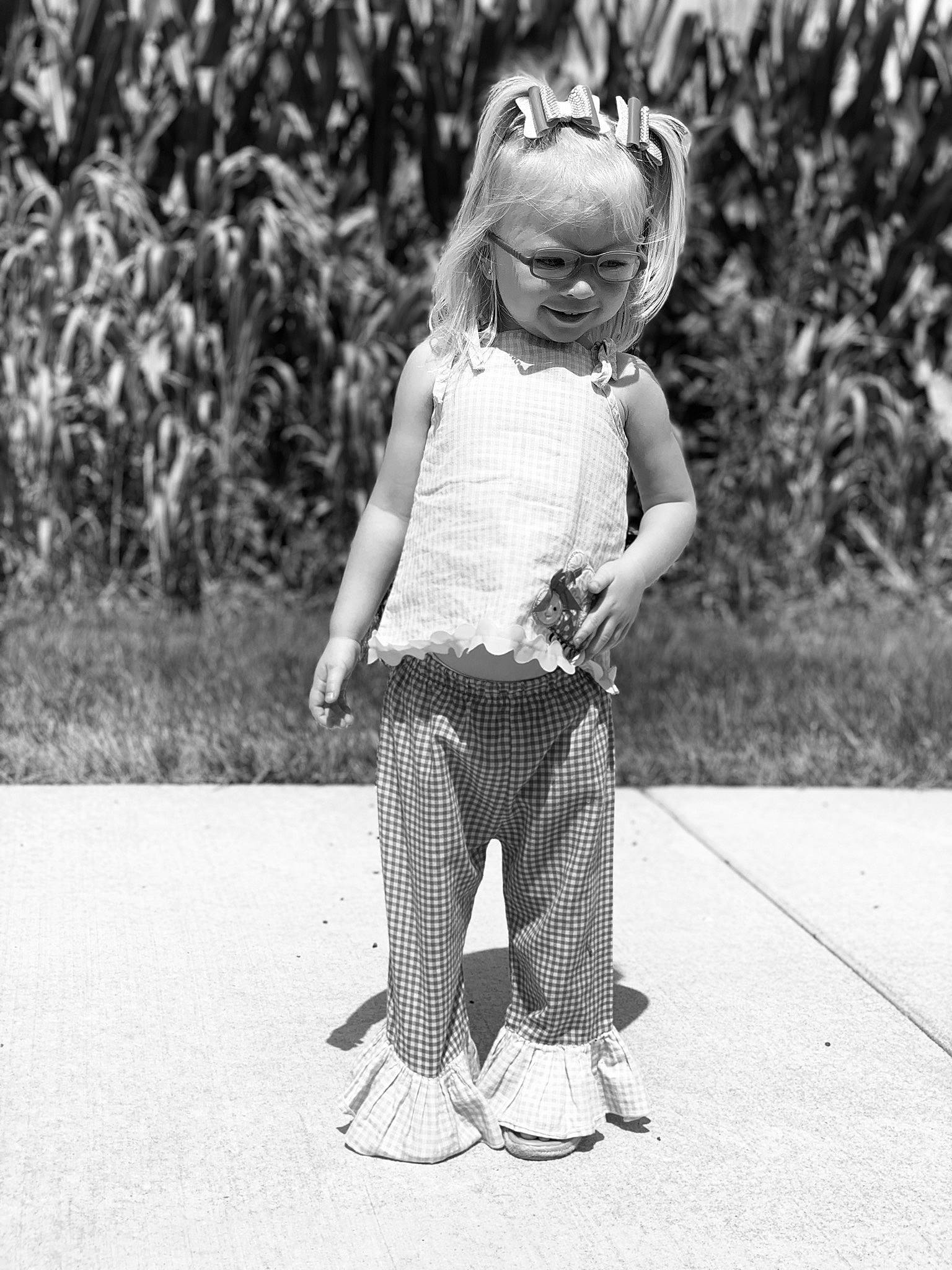 Vaydalynn is registered to the contest to win money with this photo: black, black_and_white, eyewear, gesture, grass, hairstyle, hand, happy, head, human_body, leg, mammal, monochrome, people_in_nature, person, plant, standing, street_fashion, style, toy