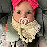 baby, infant, pacifier, headband, pink_bow, car_seat, straps, bib, beads, clothing, face, eyes, portrait, child, cute, indoor, closeup, seatbelt, baby_accessory, person