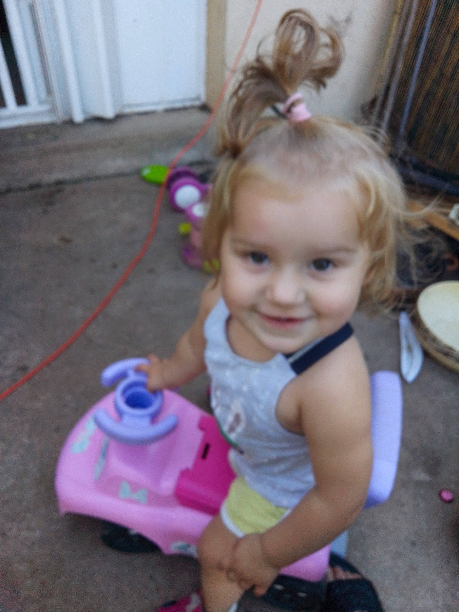 Lyana a rejoint le concours — aidez-le/la à gagner de superbes lots ! baby, baby_toddler_clothing, blond, cheek, child, facial_expression, fun, happy, head, iris, joy, magenta, person, pink, play, purple, riding_toy, sitting, skin, smile