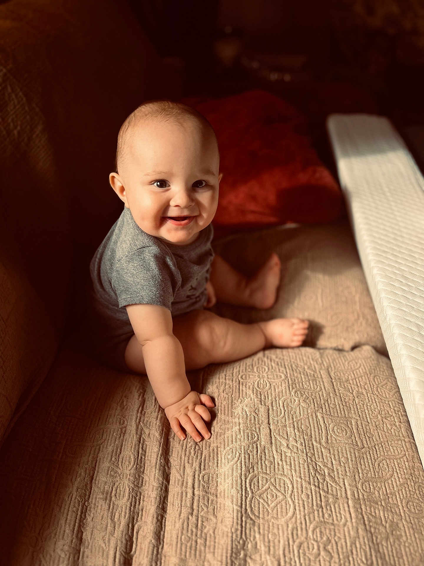 Orion is registered to the contest to win money with this photo: baby, child, smiling, sitting, couch, indoors, sunlight, warm_light, face, hand, foot, clothing, texture, fabric, comfort, cute, portrait, happy, infant, cozy