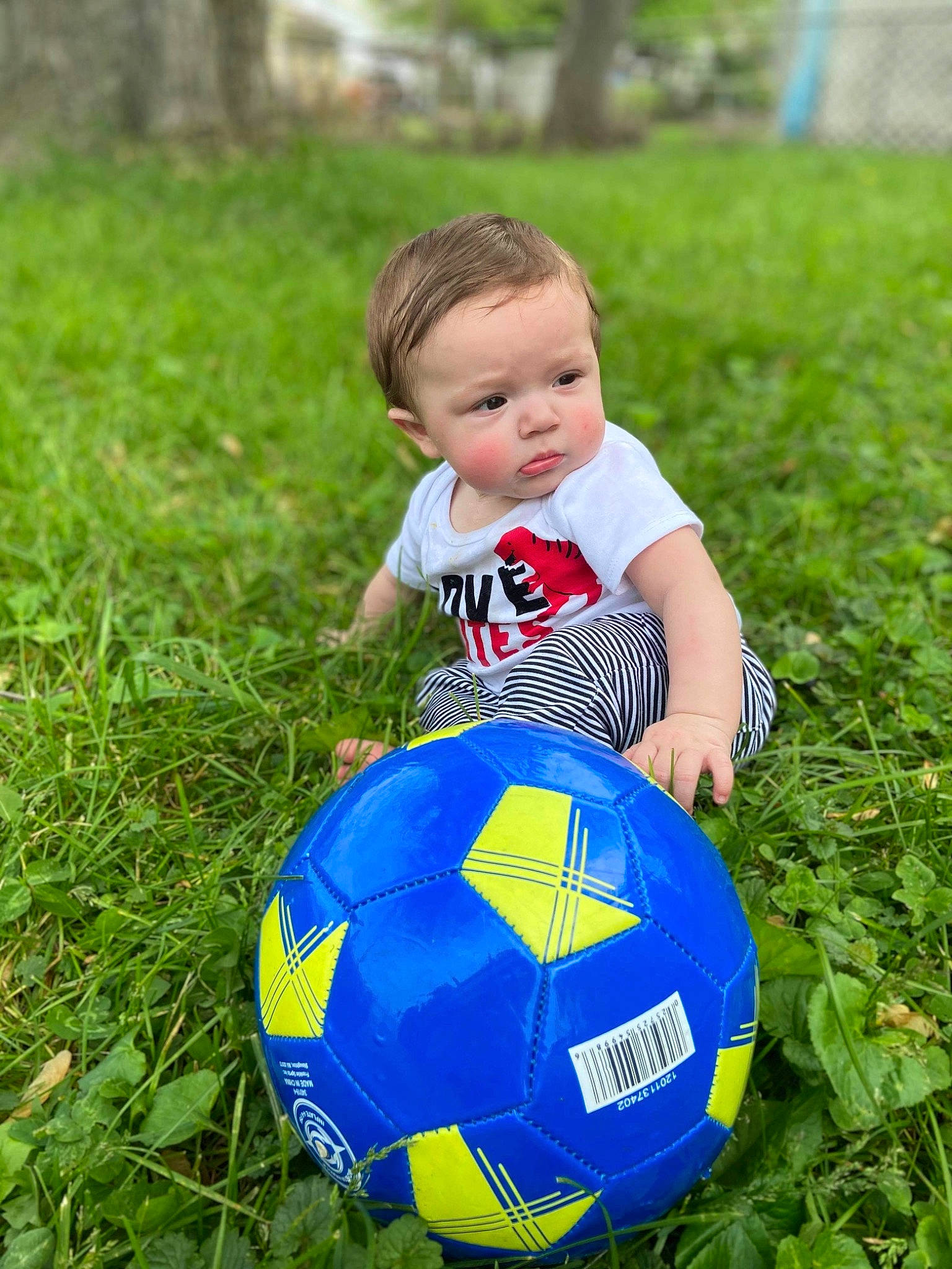 Ricky is registered to the contest to win money with this photo: baby_toddler_clothing, ball, child, electric_blue, football, fun, grass, happy, lawn, leisure, nature, people_in_nature, person, plant, playing_sports, recreation, soccer, soccer_ball, sports_equipment, toddler