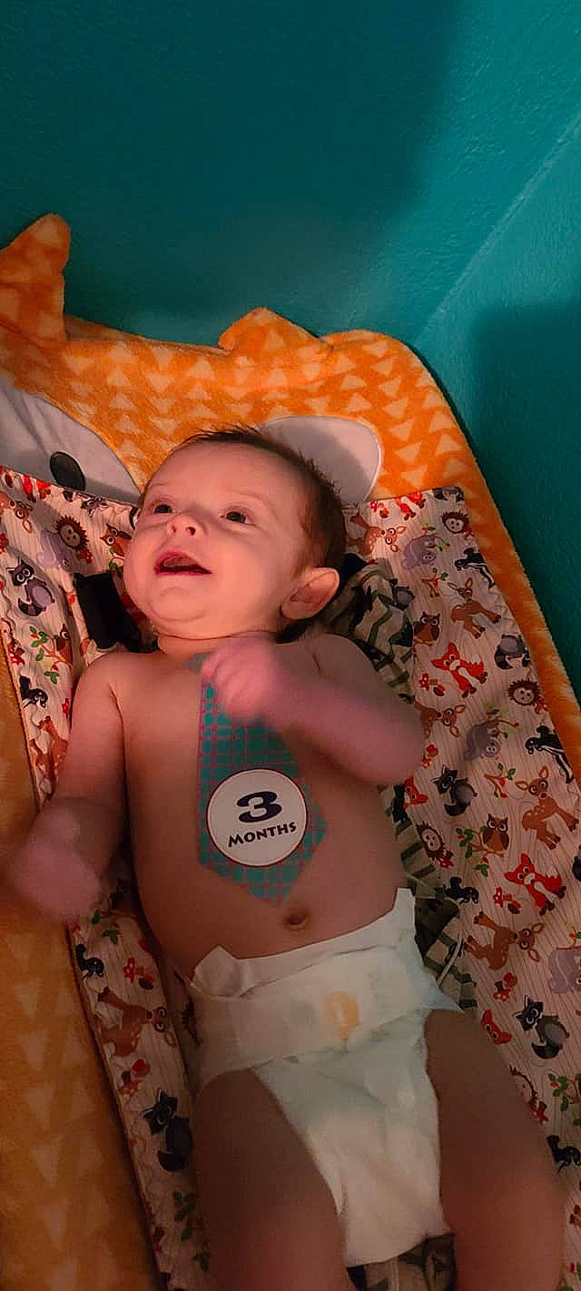 Luka is registered to the contest to win money with this photo: abdomen, baby, baby_products, baby_safety, baby_toddler_clothing, cheek, chest, child, comfort, diaper, human, linens, nose, orange, peach, person, skin, stomach, thumb, toddler