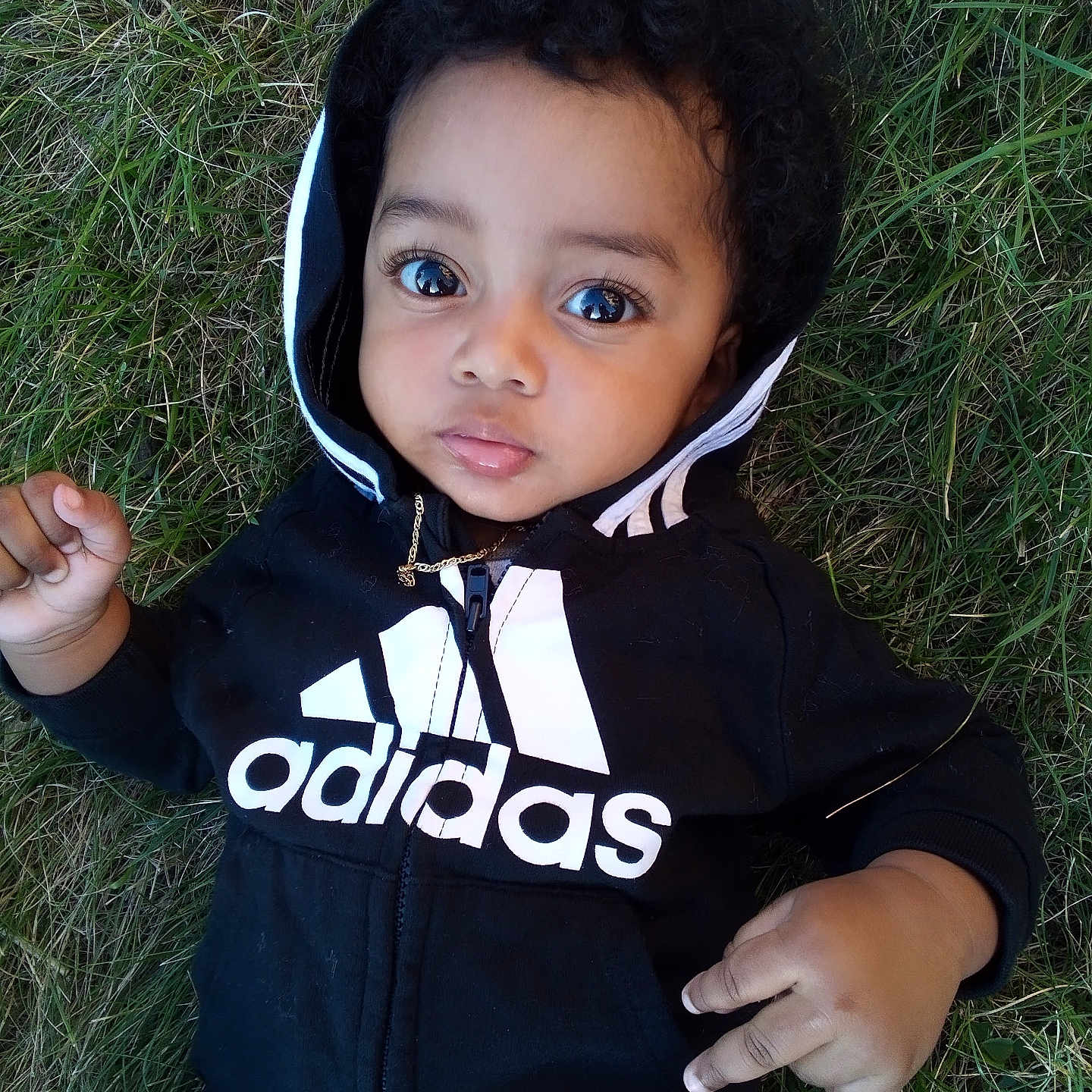 Aizayah is registered to the contest to win money with this photo: baby, bodypart, bonnet, clothing, face, finger, grass, hand, hat, head, hood, hoodie, knitwear, longsleeve, person, photography, plant, portrait, sweater, sweatshirt