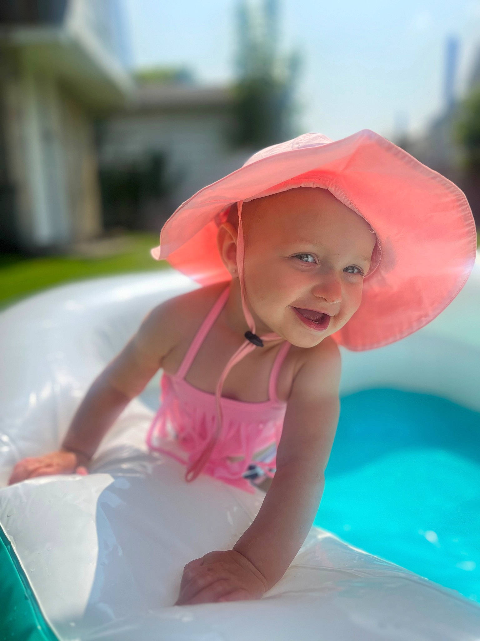 Kinsley joined the competition — help win amazing prizes! bathing, child, fashion_accessory, fun, grass, happy, hat, headwear, inflatable, leisure, magenta, person, photograph, pink, recreation, sky, smile, summer, sun_hat, swimming_pool