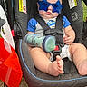 baby, child, car_seat, sunglasses, star_shaped, blue, bottle, outdoor, grass, grass_field, infant, clothing, foot, seatbelt, person, cute, summer, sunny, expression, closeup