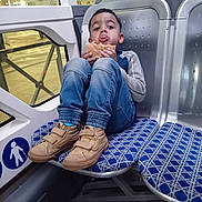 Gikka participe au concours pour gagner de l'argent avec cette photo : bodypart, boy, bread, child, clothing, face, finger, food, footwear, hand, head, jeans, male, pants, person, runningshoe, shoe, sitting, sneaker, terminal