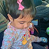 toddler, child, car_interior, pink_bow, floral_outfit, sitting, cute, indoors, seat, child_seat, toy, footwear, window, greenery_outside, portrait, young_child, casual_clothing, cartoon_overlay, heart, hair_accessory