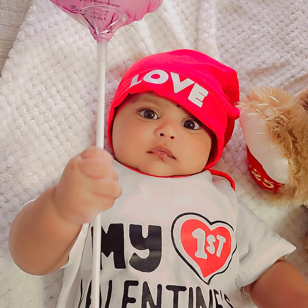 Aiden is registered to the contest to win money with this photo: baby, balloon, baseball, bodypart, bonnet, candy, cap, clothing, face, finger, food, hand, hat, head, newborn, person, photography, portrait, sweets, t_shirt