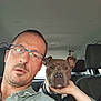 animal, beard_stubble, car, casual, collar, companion, dog, expression, glasses, hand, human, interior, man, pet, portrait, restraint, seat, seatbelt, short_hair, window